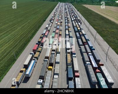 Lunga coda di camion nel porto al terminal. Vista dall'alto del parcheggio in attesa di scarico Foto Stock