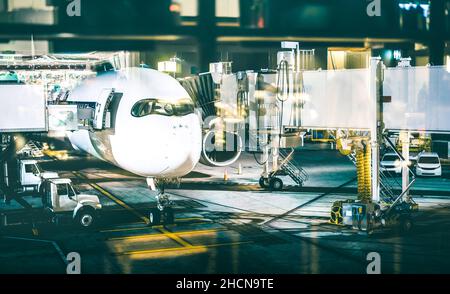 Aeroplano al cancello del terminale che prepara il decollo di notte - moderno aeroporto internazionale con l'imbarco dell'aeroplano di notte Foto Stock