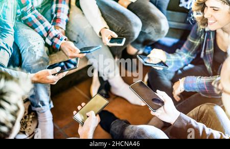 Amici di gruppo che hanno addicted il divertimento insieme usando lo smartphone moderno - mani che condividono i contenuti sul social network con lo smart phone mobile Foto Stock