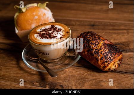 croissant dolci con panna e cappuccino su una superficie di legno Foto Stock
