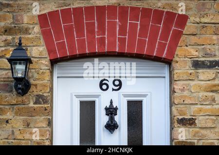Casa numero 69 sotto un arco di mattoni Foto Stock