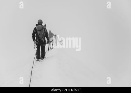 Gruppo di alpinisti del ghiacciaio su una corda Foto Stock