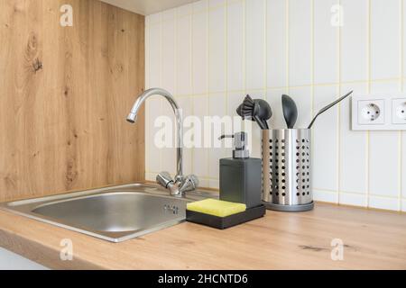 Distributori di sapone e shampoo vicino al lavello del rubinetto dell'acqua in ceramica con rubinetto in cucina costosa Foto Stock