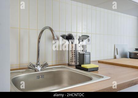 Distributori di sapone e shampoo vicino al lavello del rubinetto dell'acqua in ceramica con rubinetto in cucina costosa Foto Stock