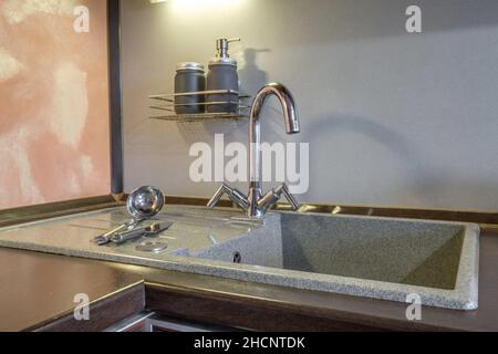 Distributori di sapone e shampoo vicino al lavello del rubinetto dell'acqua in ceramica con rubinetto in cucina costosa Foto Stock