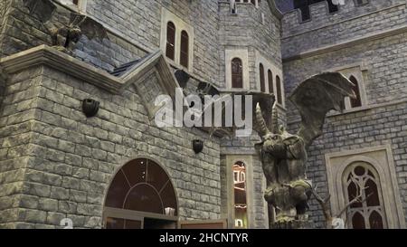 Dettagli di un nuovo parco divertimenti moderno Dream Island a Mosca, Russia. Design interno di decorazioni murali imitazione vecchia architettura con gargoyle st Foto Stock