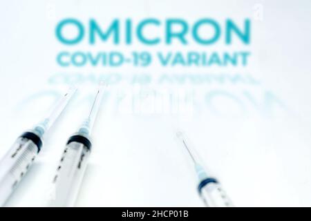 La variante Omicron Covid-19 offuscava il testo su due siringhe isolate su sfondo bianco. Mutazione del coronavirus Covid-19. Prevenzione e vaccino Foto Stock