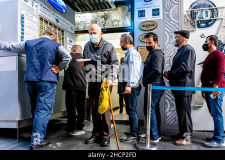 Gente del posto che accuda fuori dal negozio di pasticceria/dolci di habibah, Downtown, Amman, Jordan. Foto Stock