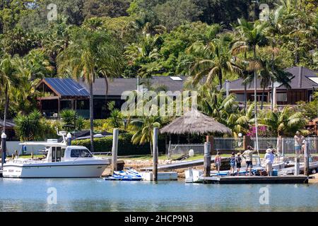 Costose case sul lungomare di Sydney con molo privato e banchine con barche e yacht nel sobborgo di Sydney di Newport su Pittwater, Australia Foto Stock