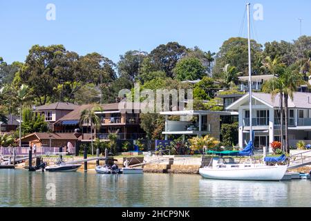 Costose case sul lungomare di Sydney con molo privato e banchine con barche e yacht nel sobborgo di Sydney di Newport su Pittwater, Australia Foto Stock