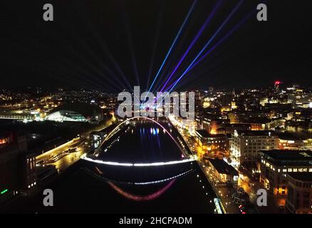 La città laser mostra dal premiato artista Seb Lee-Delisle sui famosi ponti Millennium e Tyne. Lo spettacolo laser controllato dal pubblico tramite un'app sarà attivo fino alle 10pm del giorno di Capodanno nell'ambito delle celebrazioni di Capodanno, dopo che i fuochi d'artificio sono stati cancellati a causa della pandemia. Data immagine: Giovedì 30 dicembre 2021. Foto Stock