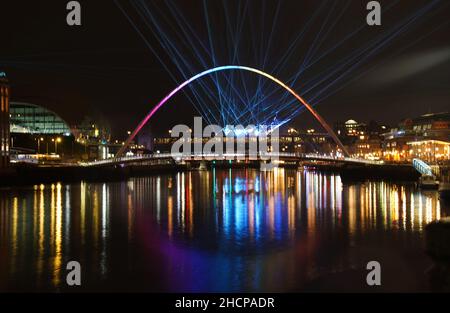 La città laser mostra dal premiato artista Seb Lee-Delisle sui famosi ponti Millennium e Tyne. Lo spettacolo laser controllato dal pubblico tramite un'app sarà attivo fino alle 10pm del giorno di Capodanno nell'ambito delle celebrazioni di Capodanno, dopo che i fuochi d'artificio sono stati cancellati a causa della pandemia. Data immagine: Giovedì 30 dicembre 2021. Foto Stock
