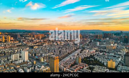 KUNMING, CINA - 30 DICEMBRE 2021 - Foto aerea scattata il 30 dicembre 2021 mostra uno spettacolare paesaggio urbano al tramonto a Kunming, provincia di Yunnan, Cina. Foto Stock