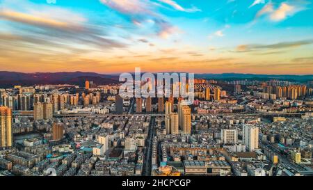 KUNMING, CINA - 30 DICEMBRE 2021 - Foto aerea scattata il 30 dicembre 2021 mostra uno spettacolare paesaggio urbano al tramonto a Kunming, provincia di Yunnan, Cina. Foto Stock