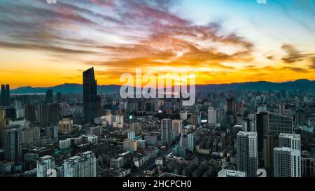 KUNMING, CINA - 30 DICEMBRE 2021 - Foto aerea scattata il 30 dicembre 2021 mostra uno spettacolare paesaggio urbano al tramonto a Kunming, provincia di Yunnan, Cina. Foto Stock