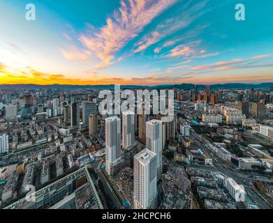 KUNMING, CINA - 30 DICEMBRE 2021 - Foto aerea scattata il 30 dicembre 2021 mostra uno spettacolare paesaggio urbano al tramonto a Kunming, provincia di Yunnan, Cina. Foto Stock