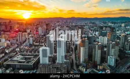 KUNMING, CINA - 30 DICEMBRE 2021 - Foto aerea scattata il 30 dicembre 2021 mostra uno spettacolare paesaggio urbano al tramonto a Kunming, provincia di Yunnan, Cina. Foto Stock