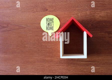 Vista dall'alto immagine di casa giocattolo in legno e bolla del discorso con testo CASA DOLCE CASA Foto Stock