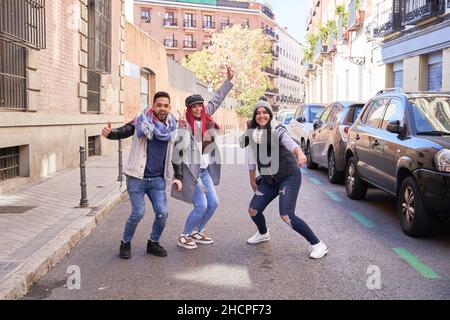 Gruppo di giovani e belli amici multietnici che si divertono, si preparano a saltare all'aria aperta in città - concetto di felicità, amicizia e lavoro di squadra. Foto Stock