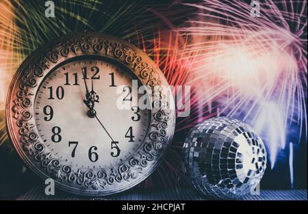 orologio di fine anno prima di mezzanotte. tostatura con bicchieri di champagne contro le luci delle feste. concetto di nuovo anno Foto Stock