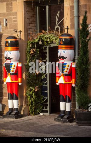 Colori vivaci dimensione della vita nut cracker Natale decorazione soldati in piedi guardia fuori di un ristorante a Perth, Scozia Foto Stock