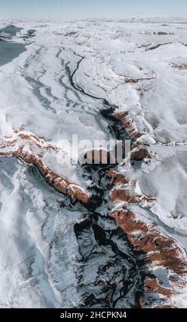 Veduta aerea del drone del canyon di Fjadrargljufur e del fiume Fjadra in inverno. Neve bianca e fiume blu. Islanda nei pressi di Reykjavik. Foto Stock