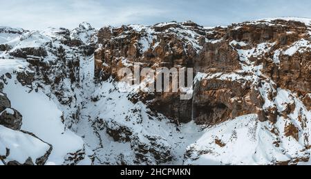 Canyon segreto chiamato canyon di Mulagljufur in Islanda del Sud. Cascata sotto la cima della montagna in inverno e paesaggio di neve. La migliore destinazione turistica. Sud Foto Stock