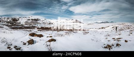 Due amici che camminano in e inverno islanda natura in Highlands attraverso montagne innevate in una bella giornata con cielo blu e sole. Foto Stock