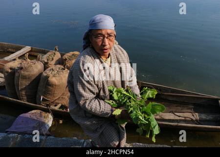 Srinagar, Jammu e Kashmir, India. 31st Dic 2021. Una donna che vende (Haak) o verdure fresche verdi del collardo durante il mercato delle pulci del venerdì a Hazratbal, Srinagar, Kashmir indiano-amministrato. Haak è una parola di Kashmiri equivalente a 'verdi' in inglese, un alimento di base dalla terra del Kashmir. Credit: Adil Abbas/ZUMA Wire/Alamy Live News Foto Stock