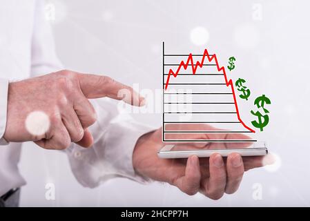 Concetto di crash del mercato azionario sopra uno smartphone tenuto da un uomo Foto Stock