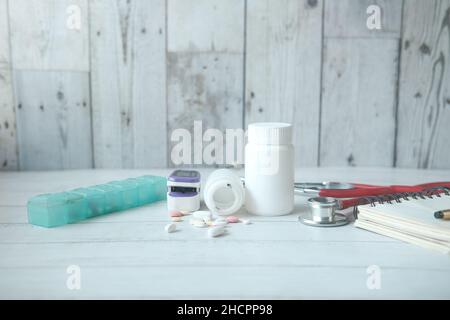 pulsossimetro, pillole mediche e blister sul tavolo Foto Stock