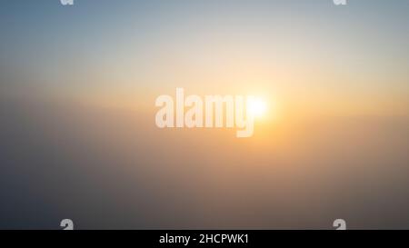 Vista aerea. Volare nella nebbia, volare nella nebbia sopra le nuvole del mattino presto nel sole nascente. Foto con fotocamera aerea. Vola sopra le nuvole verso il sole con le nuvole di nebbia che galleggiano. Misty tempo, vista dall'alto. Il punto di vista degli uccelli. Foto di alta qualità Foto Stock