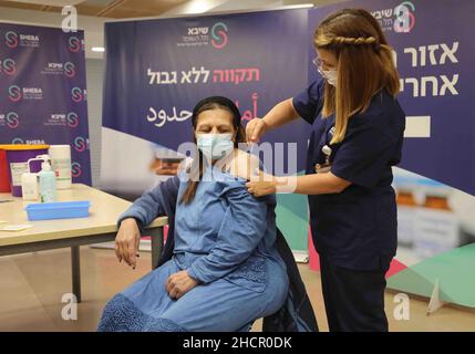 Ramat Gan. 31st Dic 2021. Una donna riceve una quarta dose di vaccino COVID-19 presso lo Sheba Medical Center nella città centrale israeliana di Ramat Gan il 31 dicembre 2021. Il Ministero della Salute israeliano, giovedì sera, ha dichiarato di aver approvato la somministrazione del quarto vaccino di richiamo contro il COVID-19 per gli adulti ad alto rischio. Credit: Gil Cohen Magen/Xinhua/Alamy Live News Foto Stock