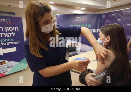 Ramat Gan. 31st Dic 2021. Una donna riceve una quarta dose di vaccino COVID-19 presso lo Sheba Medical Center nella città centrale israeliana di Ramat Gan il 31 dicembre 2021. Il Ministero della Salute israeliano, giovedì sera, ha dichiarato di aver approvato la somministrazione del quarto vaccino di richiamo contro il COVID-19 per gli adulti ad alto rischio. Credit: Gil Cohen Magen/Xinhua/Alamy Live News Foto Stock