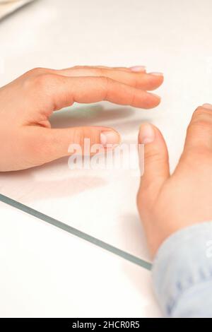Mani di una giovane donna con unghie ben curate sul tavolo manicure Foto Stock
