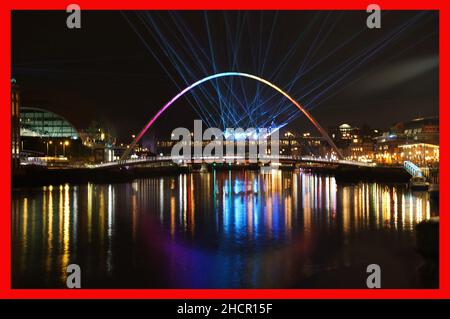 PABest la città laser mostra dal premiato artista Seb Lee-Delisle sui famosi ponti Millennium e Tyne. Lo spettacolo laser controllato dal pubblico tramite un'app sarà attivo fino alle 10pm del giorno di Capodanno nell'ambito delle celebrazioni di Capodanno, dopo che i fuochi d'artificio sono stati cancellati a causa della pandemia. Data immagine: Giovedì 30 dicembre 2021. Foto Stock