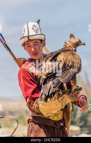 ISSYK KUL, KIRGHIZISTAN - 15 LUGLIO 2018: L'uomo locale con la sua aquila all'Ethnosestival Teskey Jeek alla costa del lago Issyk Kul in Kirghizistan Foto Stock