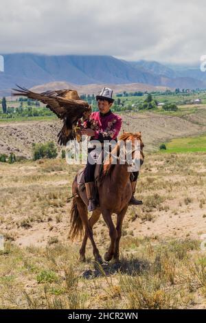 ISSYK KUL, KIRGHIZISTAN - 15 LUGLIO 2018: Cacciatore locale con la sua aquila all'Ethnosestival Teskey Jeek sulla costa del lago Issyk Kul in Kirghizistan Foto Stock