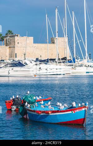 Vista su Bari con porticciolo, vecchi edifici e palme, barche colorate in legno con gabbiani, Puglia, Italia Foto Stock