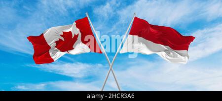 Bandiere nazionali incrociate del Canada e della bandiera di Monaco che ondeggiano nel vento al cielo nuvoloso. Simboleggiare il rapporto, il dialogo, il viaggio tra due paesi. Foto Stock