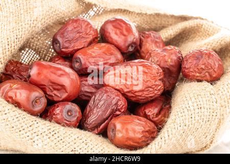 Diverse bacche di ziziphus essiccate con un sacchetto di iuta, primo piano, Foto Stock