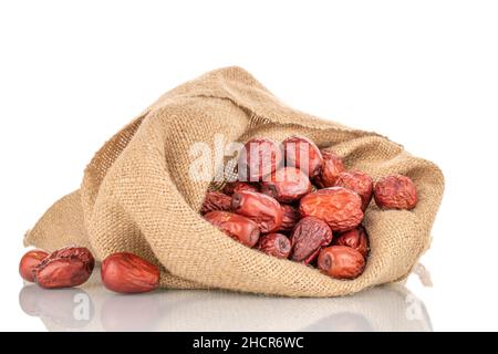 Diverse bacche di ziziphus essiccate con un sacchetto di iuta, primo piano, isolato su bianco. Foto Stock