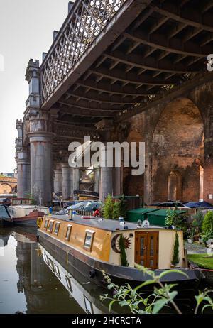 Regno Unito, Inghilterra, Manchester, Castlefield, bacino del canale Bridgewater, canale residenziale narrowboat ormeggiato sotto viadotto ferroviario ridondante Foto Stock