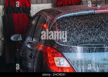 Acqua in schiuma per autolavaggio, autolavaggio automatico in azione Foto Stock