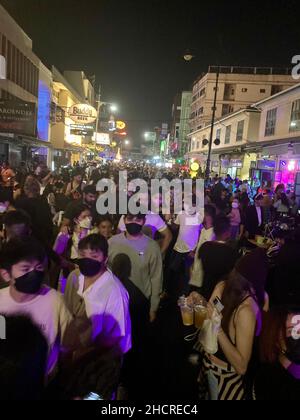 Bangkok, Tailandia. 31st Dic 2021. Decine di migliaia di abitanti del luogo e turisti festeggiano la vigilia di Capodanno nella famosa strada per zaino in spalla Mile Khaosan a Bangkok. La Thailandia è una delle poche destinazioni a lunga distanza dove attualmente soggiornano numerosi turisti. Credit: Carola Frentzen/dpa/Alamy Live News Foto Stock