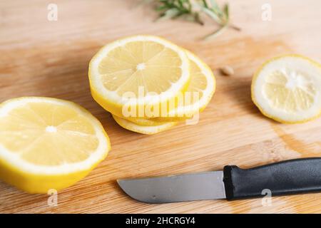 Fette di limone su un tavolo di legno da taglio Foto Stock