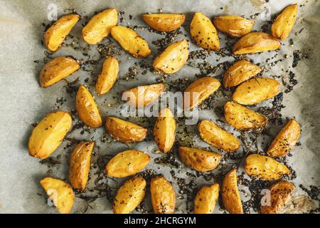 Fette di patate al forno con rosmarino e olio - verdure biologiche fatte in casa vegano vegetariano patate spicchi snack pasto. Foto Stock