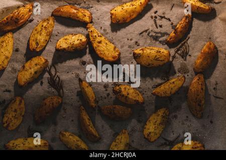 Fette di patate al forno con rosmarino e olio - verdure biologiche fatte in casa vegano vegetariano patate spicchi snack pasto. Foto Stock
