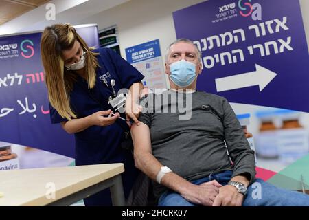 Ramat Gan, Israele. 31st Dic 2021. (211231) -- RAMAT GAN (ISRAELE), 31 dicembre 2021 (Xinhua) -- Un uomo riceve la sua quarta dose del vaccino COVID-19 presso lo Sheba Medical Center di Ramat Gan, Israele centrale, il 31 dicembre 2021. Il Ministero della Sanità israeliano ha dichiarato di aver approvato la somministrazione del quarto vaccino di richiamo sparato contro COVID-19 per i residenti e il personale delle case di cura. (Tomer Neuberg/JINI via Xinhua) Credit: Xinhua/Alamy Live News Foto Stock