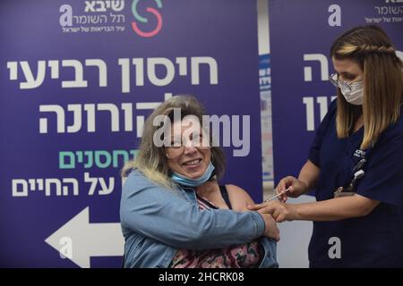 Ramat Gan, Israele. 31st Dic 2021. (211231) -- RAMAT GAN (ISRAELE), 31 dicembre 2021 (Xinhua) -- Una donna riceve la sua quarta dose del vaccino COVID-19 presso lo Sheba Medical Center di Ramat Gan, Israele centrale, il 31 dicembre 2021. Il Ministero della Sanità israeliano ha dichiarato di aver approvato la somministrazione del quarto vaccino di richiamo sparato contro COVID-19 per i residenti e il personale delle case di cura. (Tomer Neuberg/JINI via Xinhua) Credit: Xinhua/Alamy Live News Foto Stock